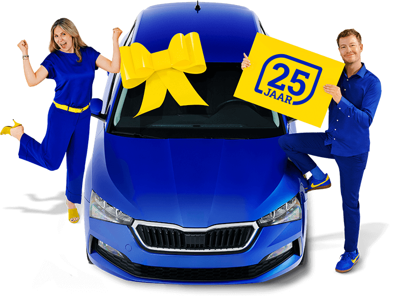 Een lachende man en vrouw in blauwe kleding naast een blauwe auto. De man rechts houdt een bord omhoog met de tekst '25 jaar'. De sfeer is feestelijk.